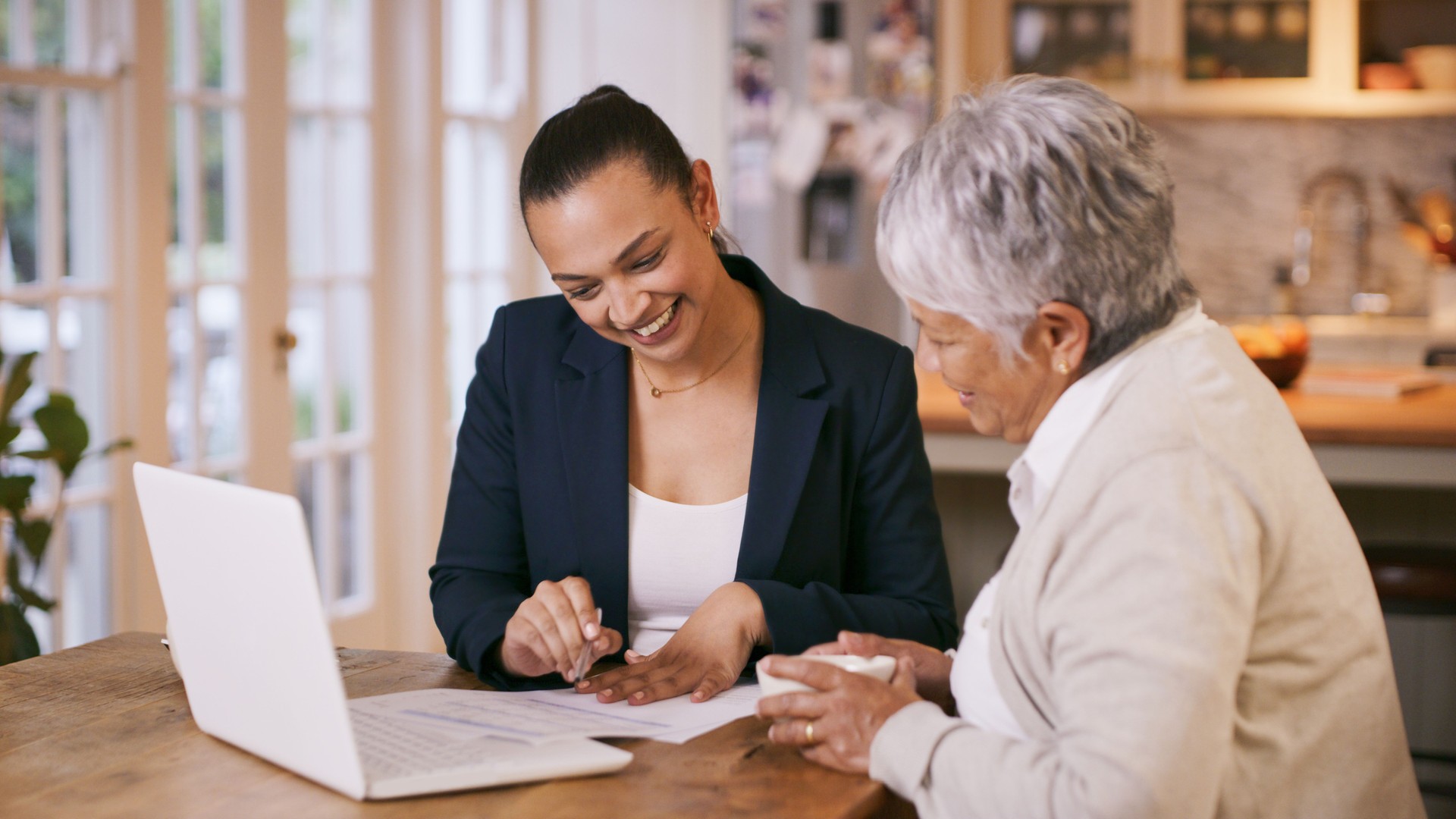 Shot of a consultant going through paperwork during a meeting with a senior woman at home